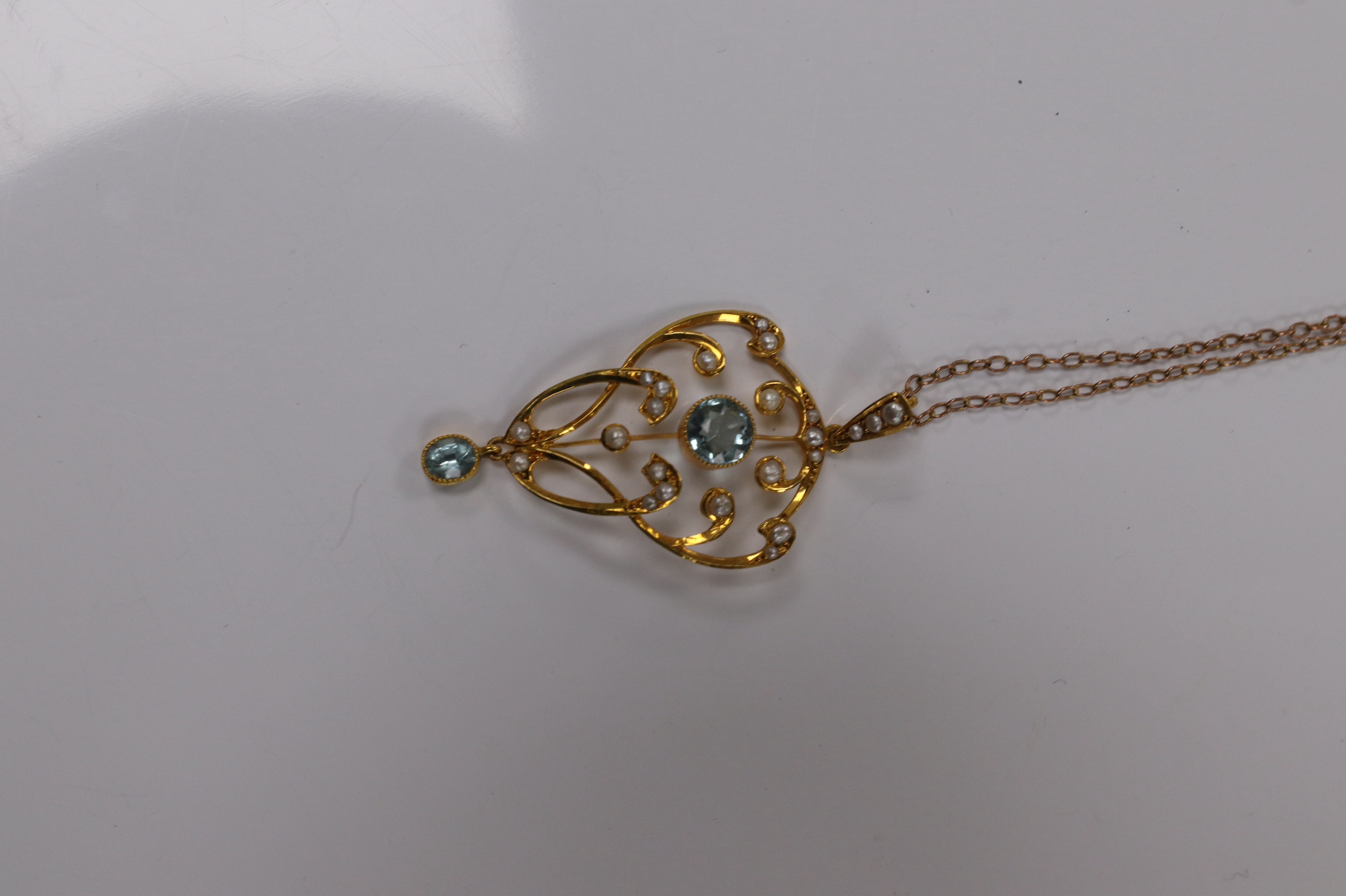 An Edwardian 9ct and gem set drop pendant, 45mm, on a yellow metal fine link chain, 36cm, gross weight 4.2 grams. Condition - good